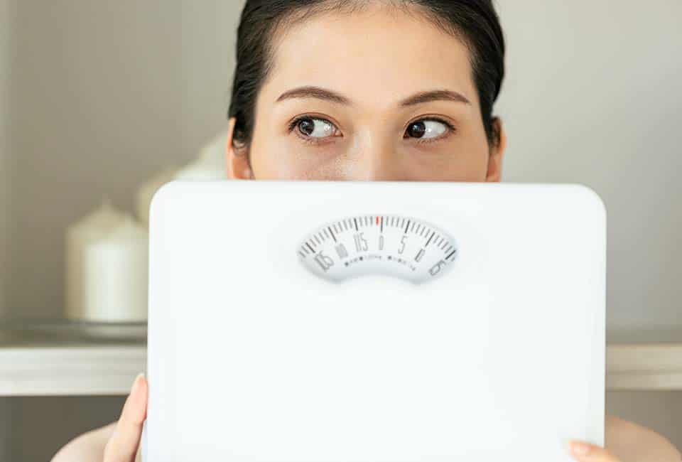 体重計を持つ女性